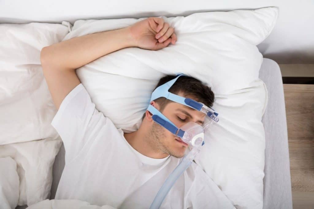man sleeping with a CPAP machine