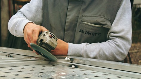 man polishing a steel using a sander